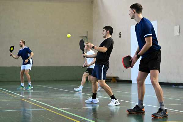 Badminton equipment sits on the floor inside a hall